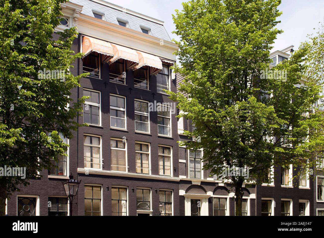 Voir l'historique des bâtiments typiques et traditionnelles, montrant un style architectural hollandais et les arbres à Amsterdam. Il s'agit d'une journée ensoleillée. Banque D'Images