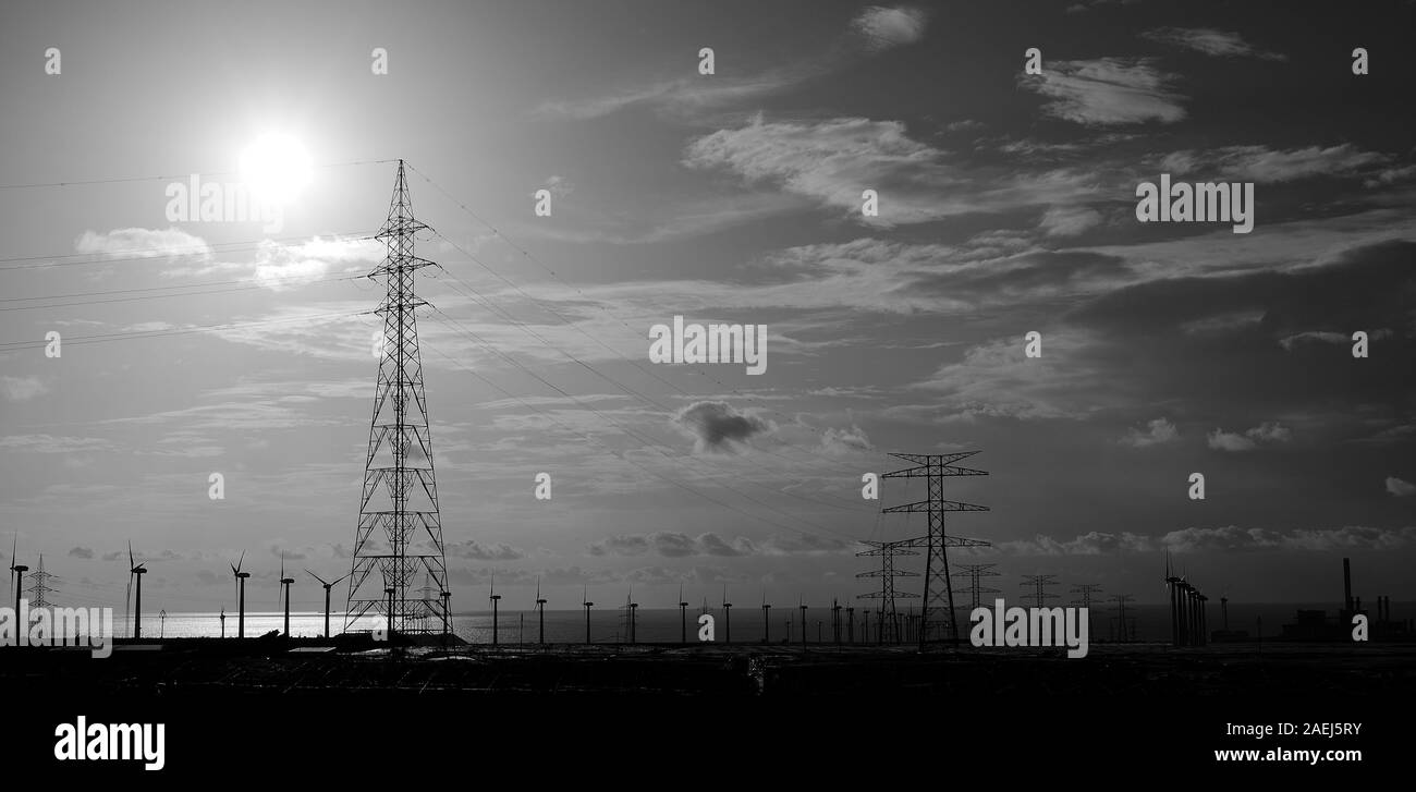 Paysage industriel au lever du soleil avec des tours de haute tension et les éoliennes, le mode monochrome Banque D'Images