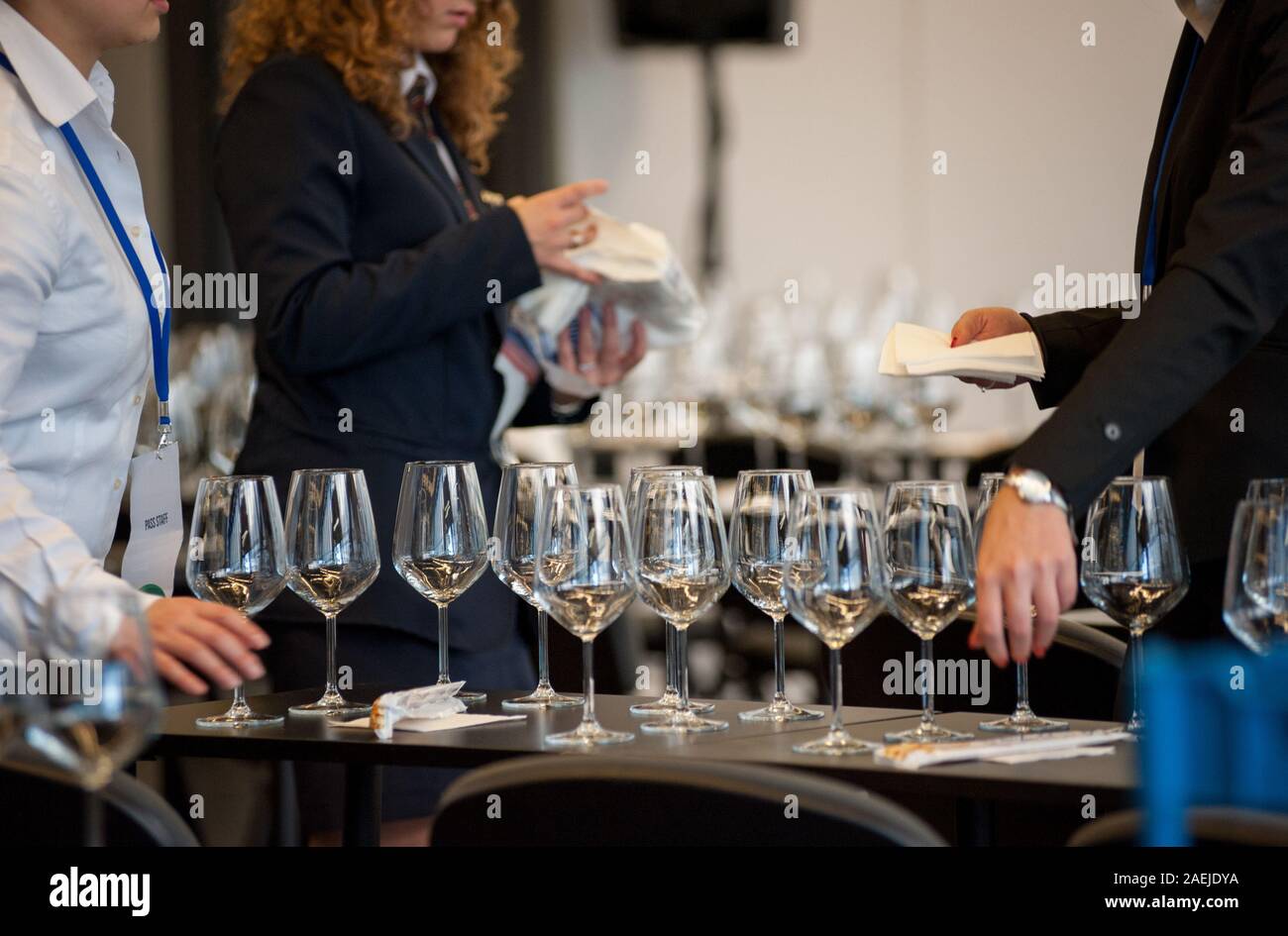 Jeu de serveuse les tables avec crystal gobles pour un atelier de dégustation de vin. Service de restauration et le personnel de salle à manger au travail. Banque D'Images