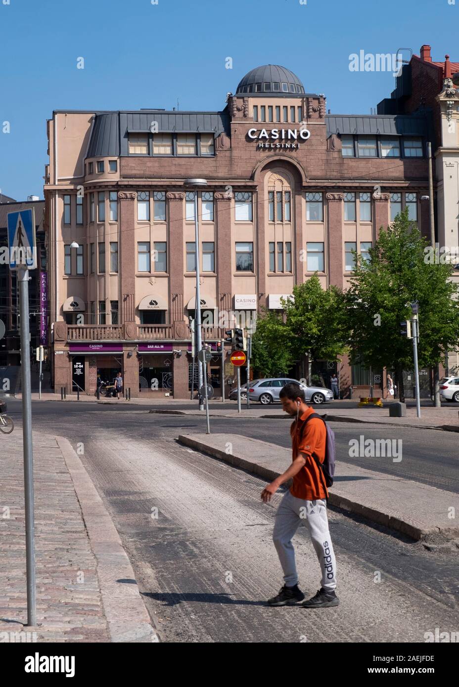 Vue latérale du jeune homme crossing street en face de la place Rautatientori Casino Helsinki, Helsinki, Finlande, Scandinavie, Europe Banque D'Images
