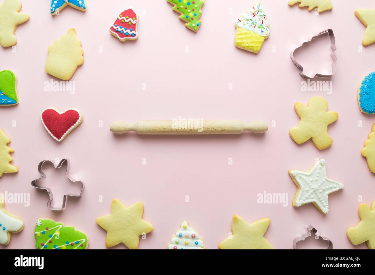 Motif de biscuits de Noël et d'un emporte-pièce avec rouleau à pâtisserie résumé sur rose. L'espace pour copier. Banque D'Images
