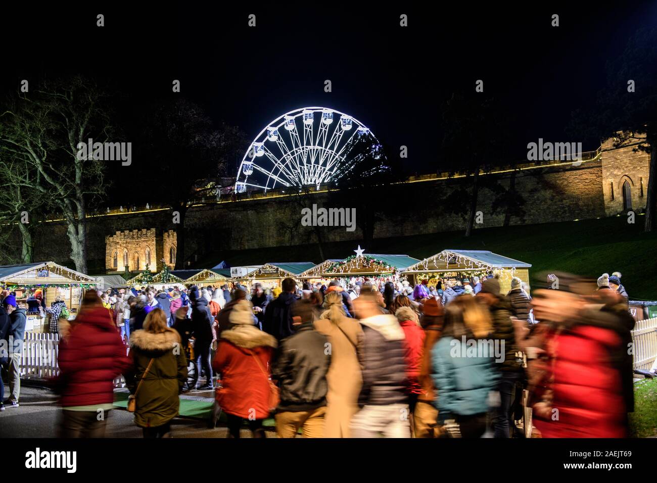 Les étals du marché de Noël de Lincoln à l'intérieur des terres du château de Lincoln dans la nuit, avec la grande roue en arrière-plan. Banque D'Images