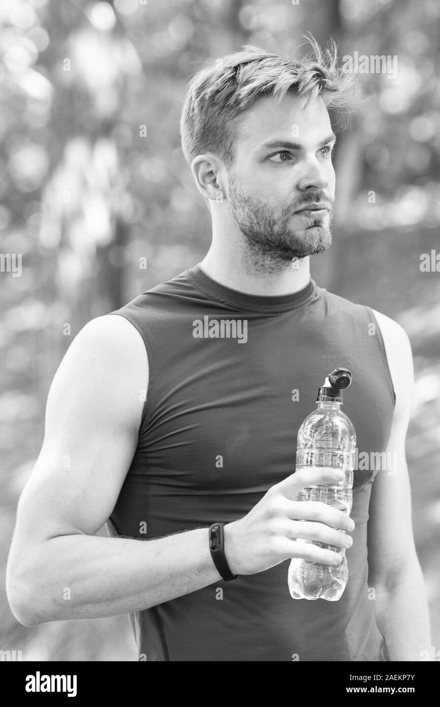 Power balance. Soins du corps hydratation. Le sport et la santé. l'homme  dans les vêtements de sport boire de l'eau. rafraîchissant verre de  vitamines après entraînement. athletic homme avec une bouteille d'eau.