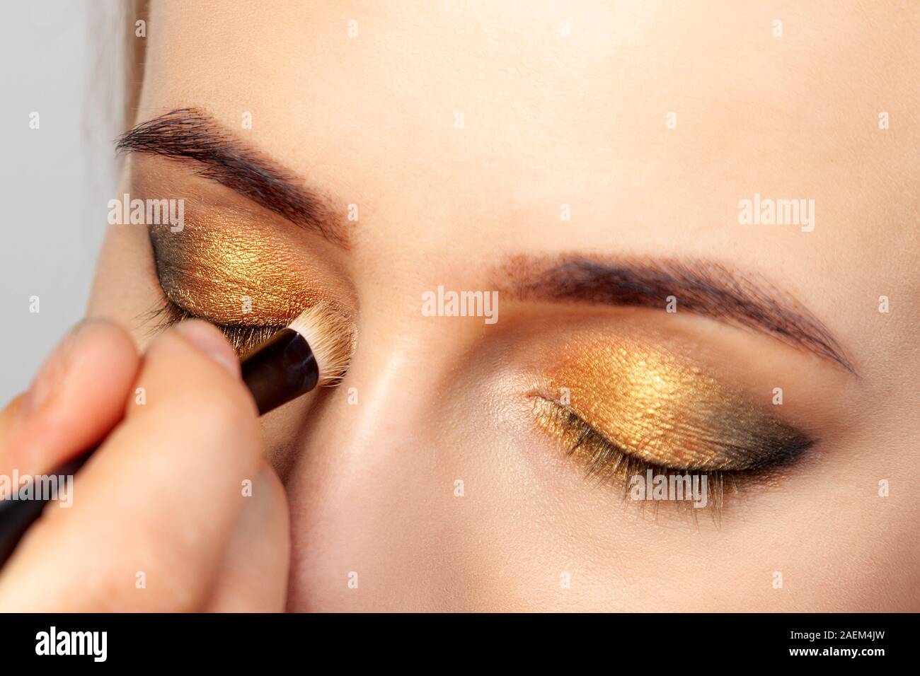 Close-up de l'application de maquillage dans le salon sur le modèle dans le  style oriental, le make-up artist mettre des tons brun doré et vert dans  les coins Photo Stock - Alamy