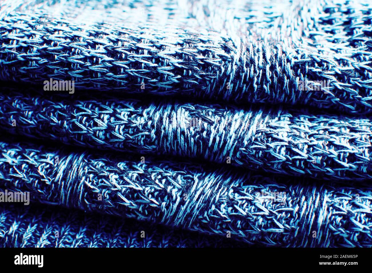 La texture de la laine tricot bleu tricot avec motif câble comme arrière-plan. Chandail tricoté. Couleur bleu classique de 2020. Banque D'Images