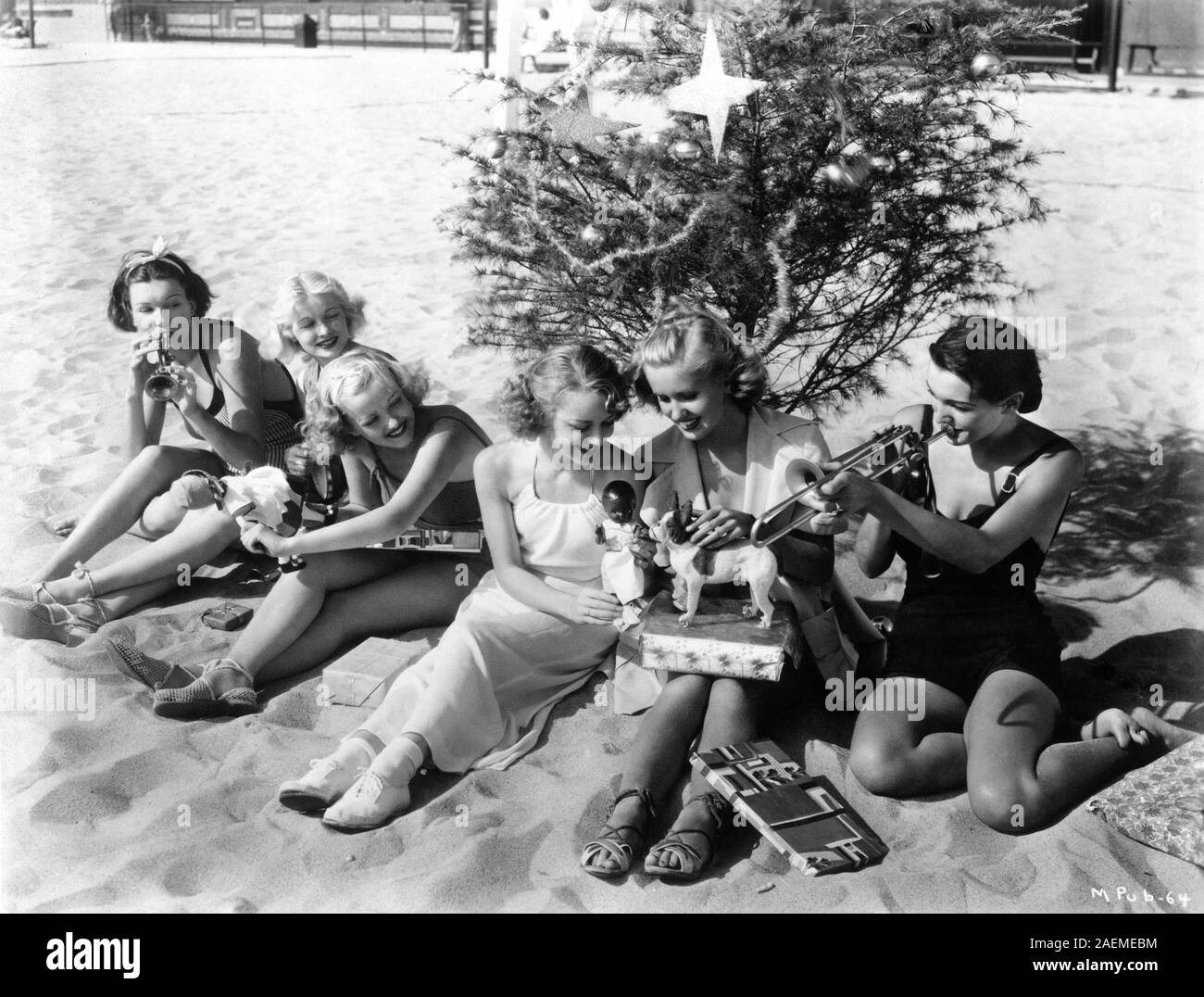 Des starlettes d'hollywood MAXINE JENNINGS LUCILLE BALL PHYLLIS BROOKS ANNE SHIRLEY JANE HAMILTON ET KAY SUTTON avec l'arbre de Noël et présente sur la plage de Santa Monica en Californie Décembre 1935 RKO Radio Pictures Publicité Banque D'Images