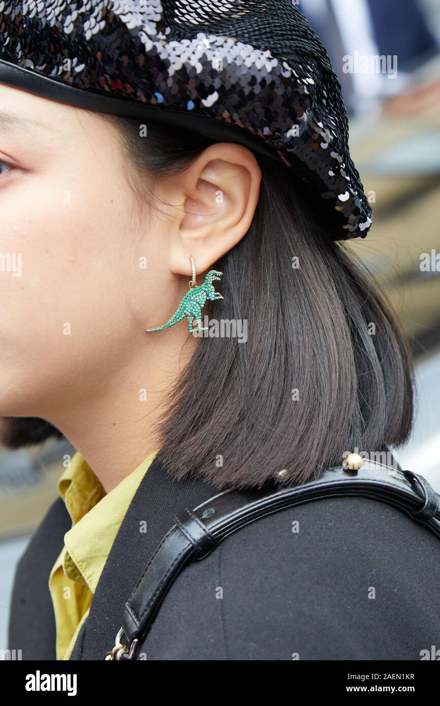 MILAN, ITALIE - 22 septembre 2019 : Femme avec dinosaure vert et noir sequin hat earring avant Fila fashion show, Milan Fashion Week street style ? Banque D'Images