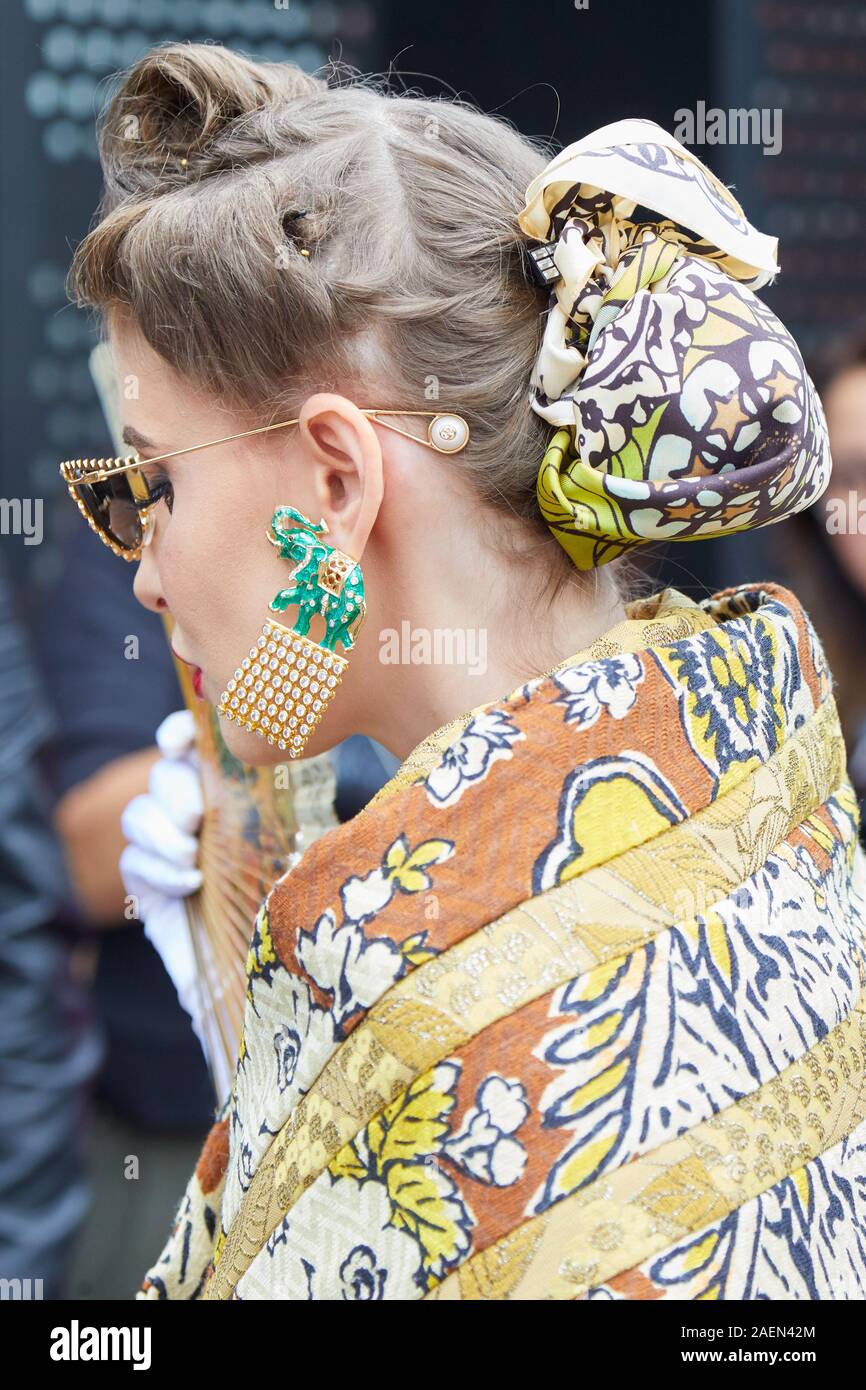 MILAN, ITALIE - 22 septembre 2019 : Femme avec earring en forme d'éléphant vert et marron, doré et kimono jaune avant Gucci fashion show, Milan Banque D'Images