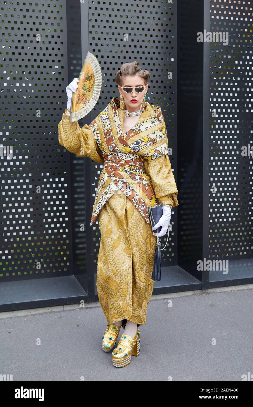 MILAN, ITALIE - 22 septembre 2019 : Femme avec kimono d'or et le ventilateur avant Gucci fashion show, Milan Fashion Week street style ? Banque D'Images
