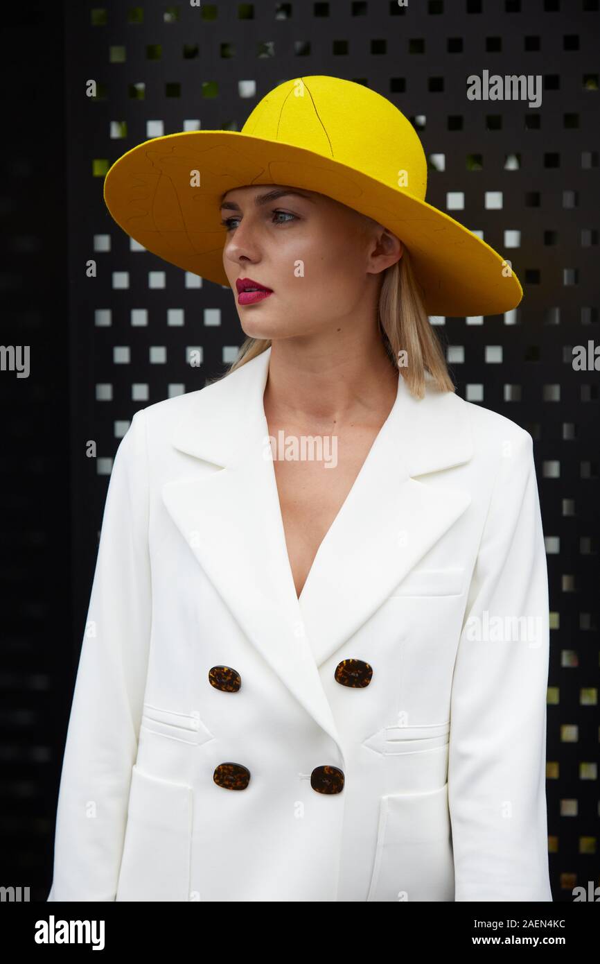 MILAN, ITALIE - 22 septembre 2019 : Femme avec veste blanche et jaune hat avant Gucci fashion show, Milan Fashion Week street style ? Banque D'Images