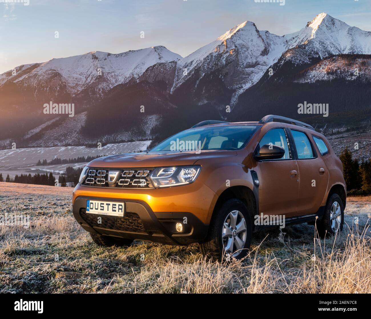Dacia Duster SUV sur une prairie givrée sur fond de montagne enneigée peaks Banque D'Images