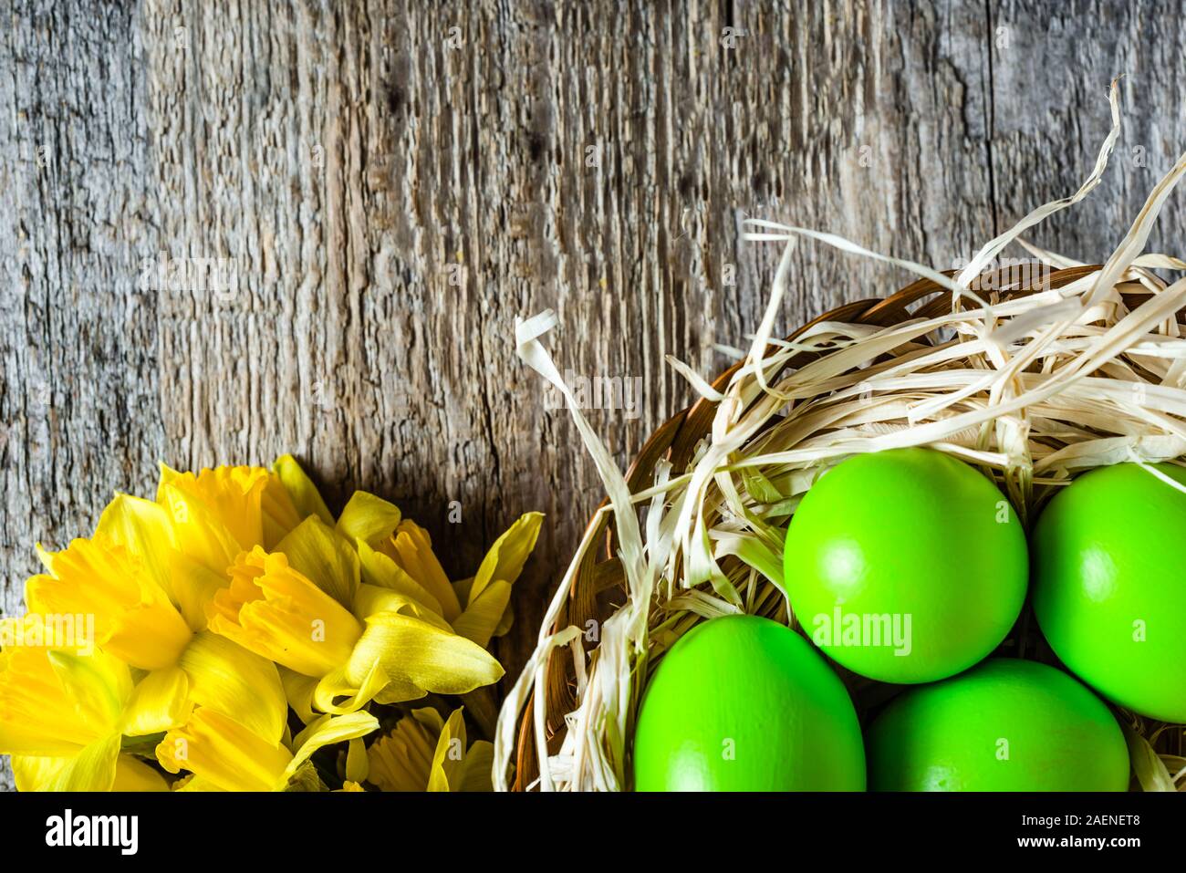 Arrière-plan de Pâques avec les jonquilles et les oeufs de Pâques dans le panier Banque D'Images