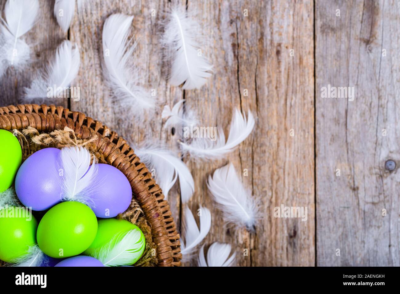 Arrière-plan avec des oeufs de Pâques dans le panier, des oeufs colorés, vue du dessus Banque D'Images