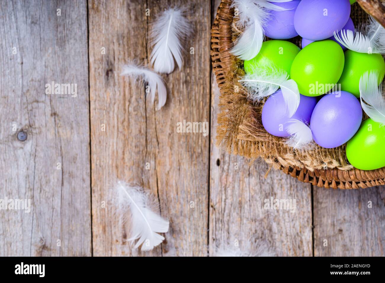 Arrière-plan de Pâques avec les oeufs de Pâques colorés dans le panier en bois sur les conseils rustique Banque D'Images
