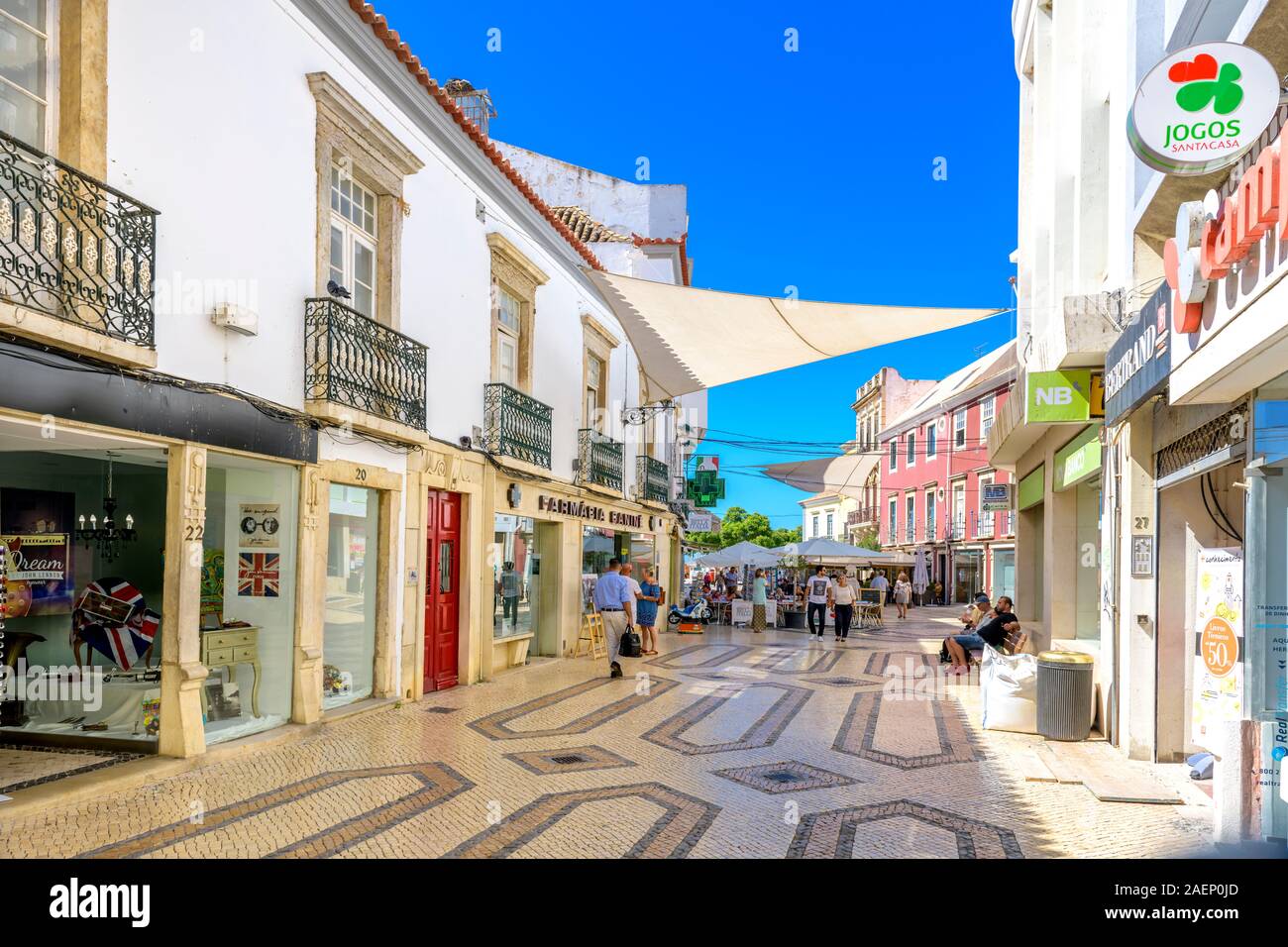 Boutiques de Faro et restaurant en plein air dans une rue pavée traditionnelle avec des pavés portugais traditionnels, centre commercial Calcada Faro, Algarve Portugal. Banque D'Images