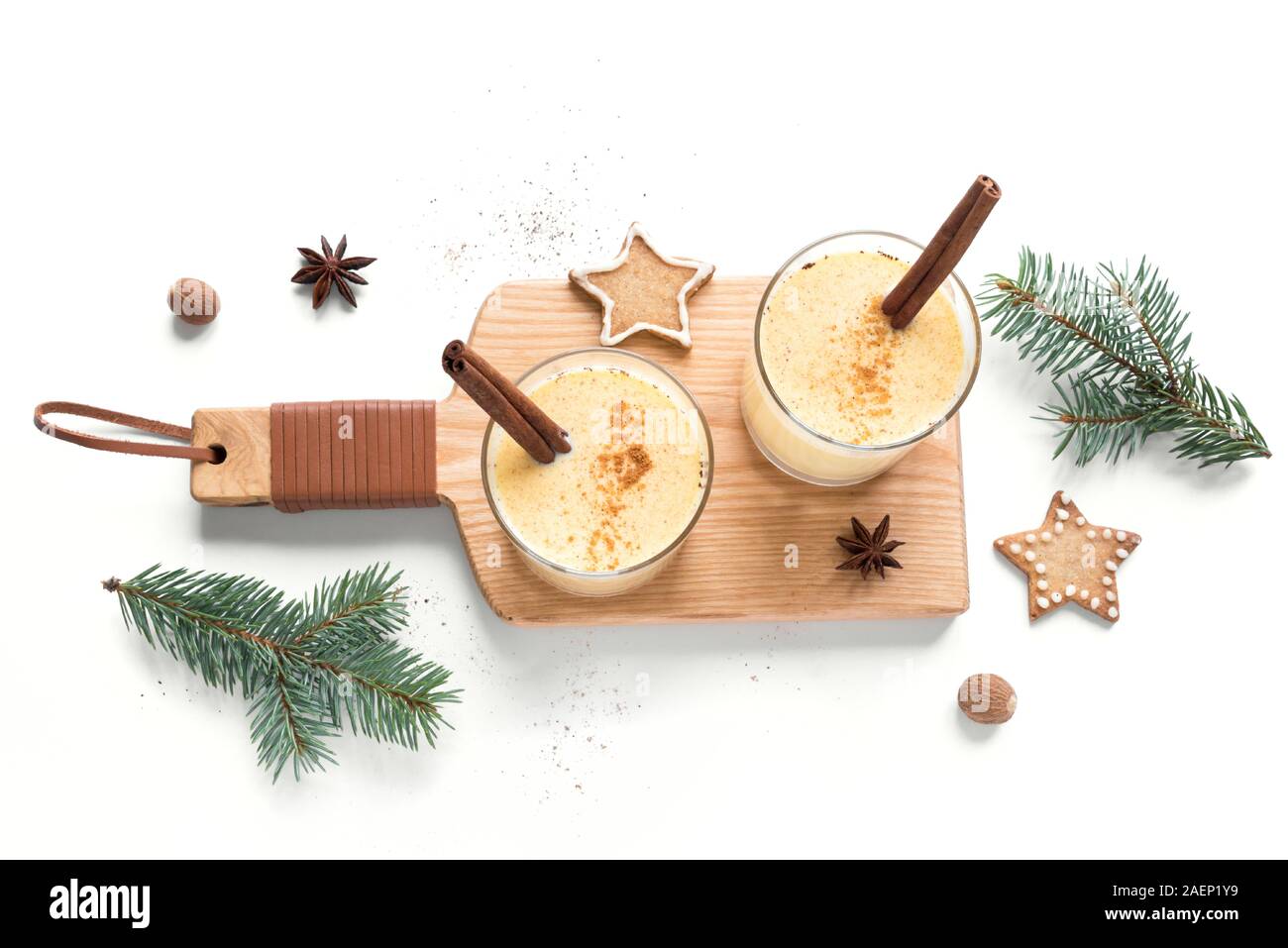 Noël avec un verre de lait de poule de muscade râpée et des bâtons de cannelle pour Noël et vacances d'hiver, isolé sur fond blanc, vue du dessus. Banque D'Images