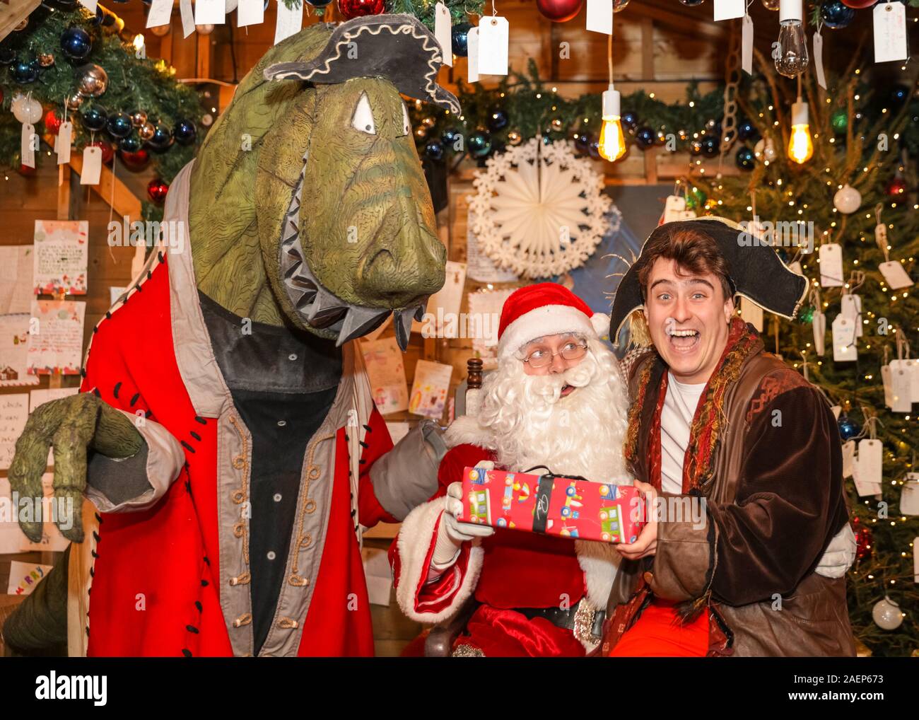 Londres, Royaume-Uni. Dec 10, 2019. Le capitaine Flinn et le 7ft de haut Mr T-Rex visiter le Père Noël à Leicester Square Santa's Grotto pour savoir qui est faite à l'impertinent et listes de nice cette année, avec des artistes de la compagnie de théâtre Les Petits. Le capitaine et les Dinosaures Pirate Flinn est le titre spectacle familial à 'Noël à Leicester Square' ce décembre au Spiegeltent. Il dispose de la marionnette, de la musique et ignoble dinosaures, basé sur le bien-aimé, primé livre pour enfants. Credit : Imageplotter/Alamy Live News Banque D'Images