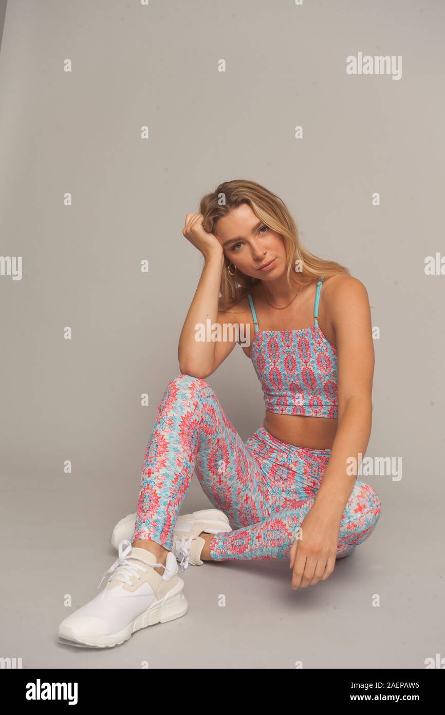 Jeune femme Slim dans le sport tenue sexy woman wearing colorful serre pantalon de sport et le haut dans un mouvement isole en studio London UK 02 dec 2019 Photo Stock Alamy