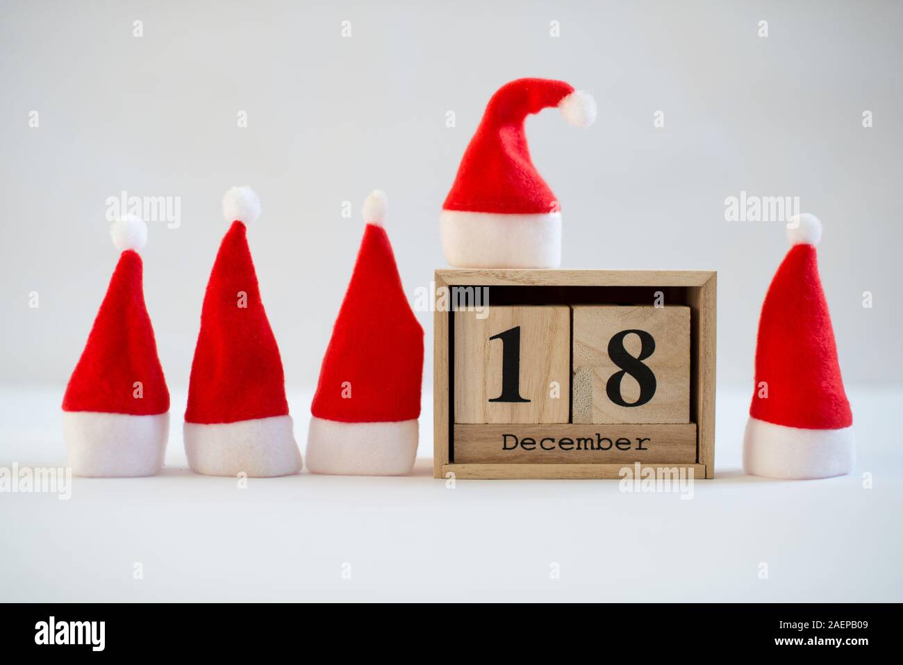 Calendrier en bois Cube affichant la date le 18 décembre avec des petits Santa hats sur fond blanc. Calendrier de l'Avent, Noël arrière-plan, Copy space Banque D'Images
