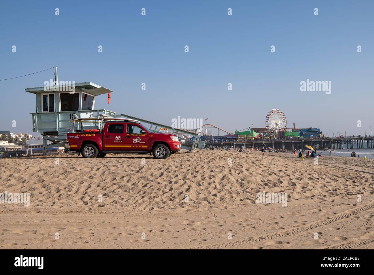 Véhicule de garde-vie stationné sur la plage avec tour de maître-nageur et jetée de Santa Monica en arrière-plan, Californie, États-Unis Banque D'Images