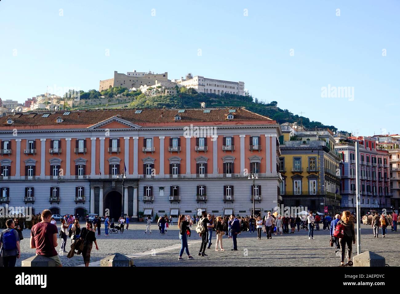 Voir des gens dans la la Piazza del Plebiscito et la forteresse médiévale, le château Sant'Elmo, située sur la colline au-dessus, Naples, Italie. Banque D'Images