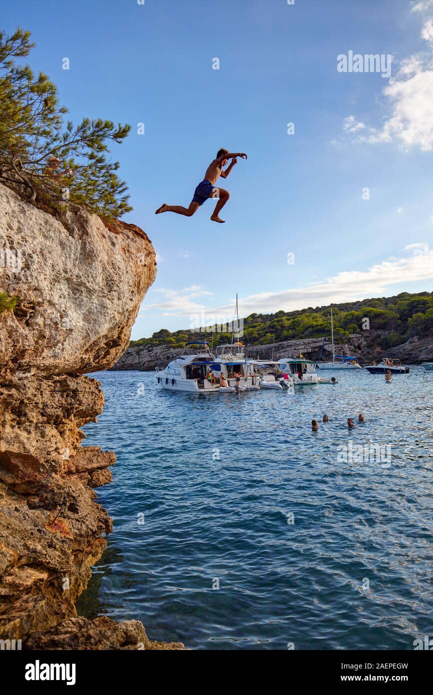 Garçon plongeant de rochers à Cala en Turqueta, Minorque, Iles Baléares, Espagne Banque D'Images