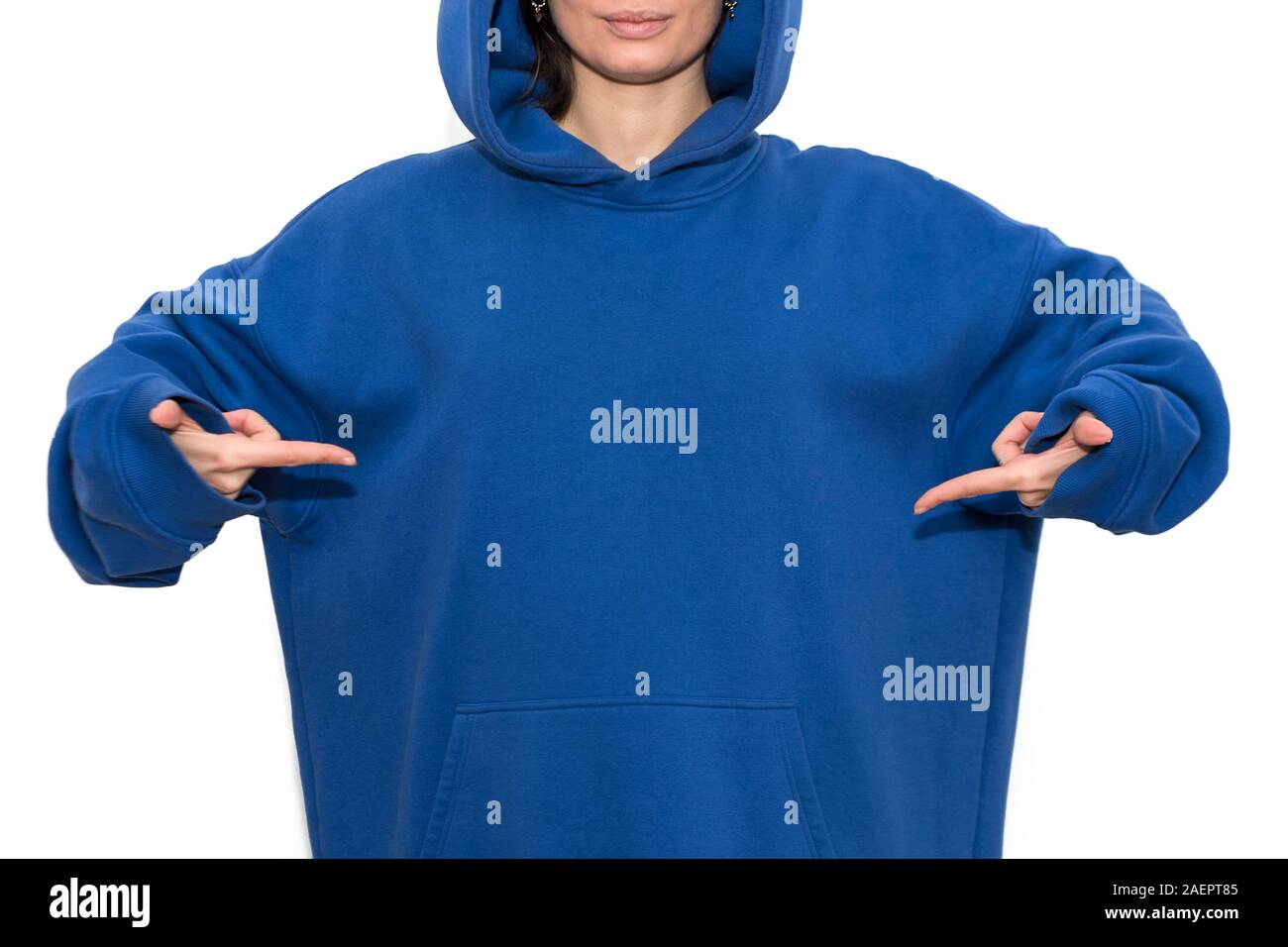 Jeune hipster girl wearing blue hoodie et pointer du doigt avec de l'espace  pour votre logo ou design. Woman pointing de poitrine avec les deux mains,  copy space Photo Stock - Alamy