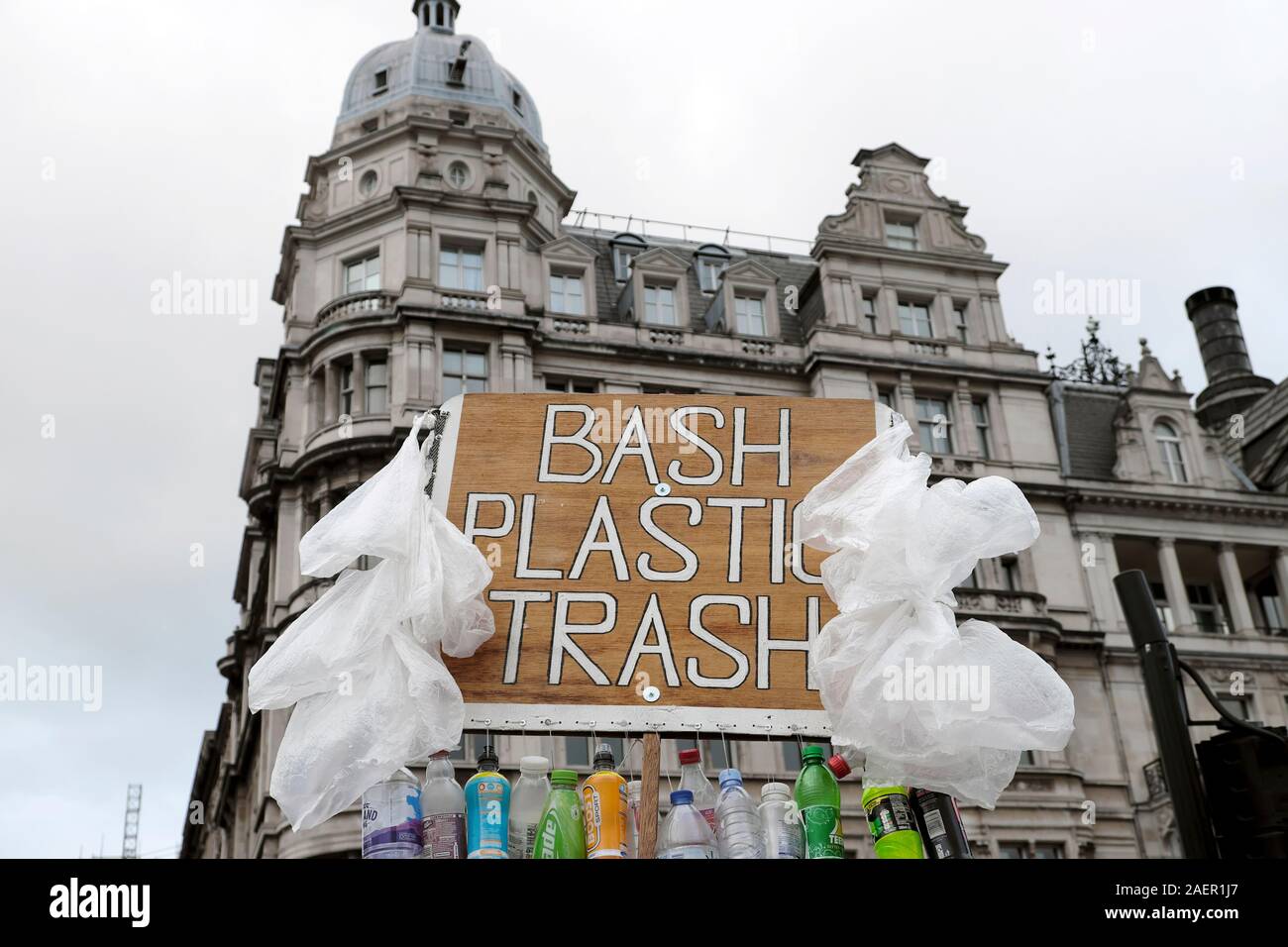 Manifestant l'homme avec des bouteilles en plastique pour protester avec placard contre l'utilisation de plastique dans la ville de Westminster London England UK KATHY DEWITT Banque D'Images