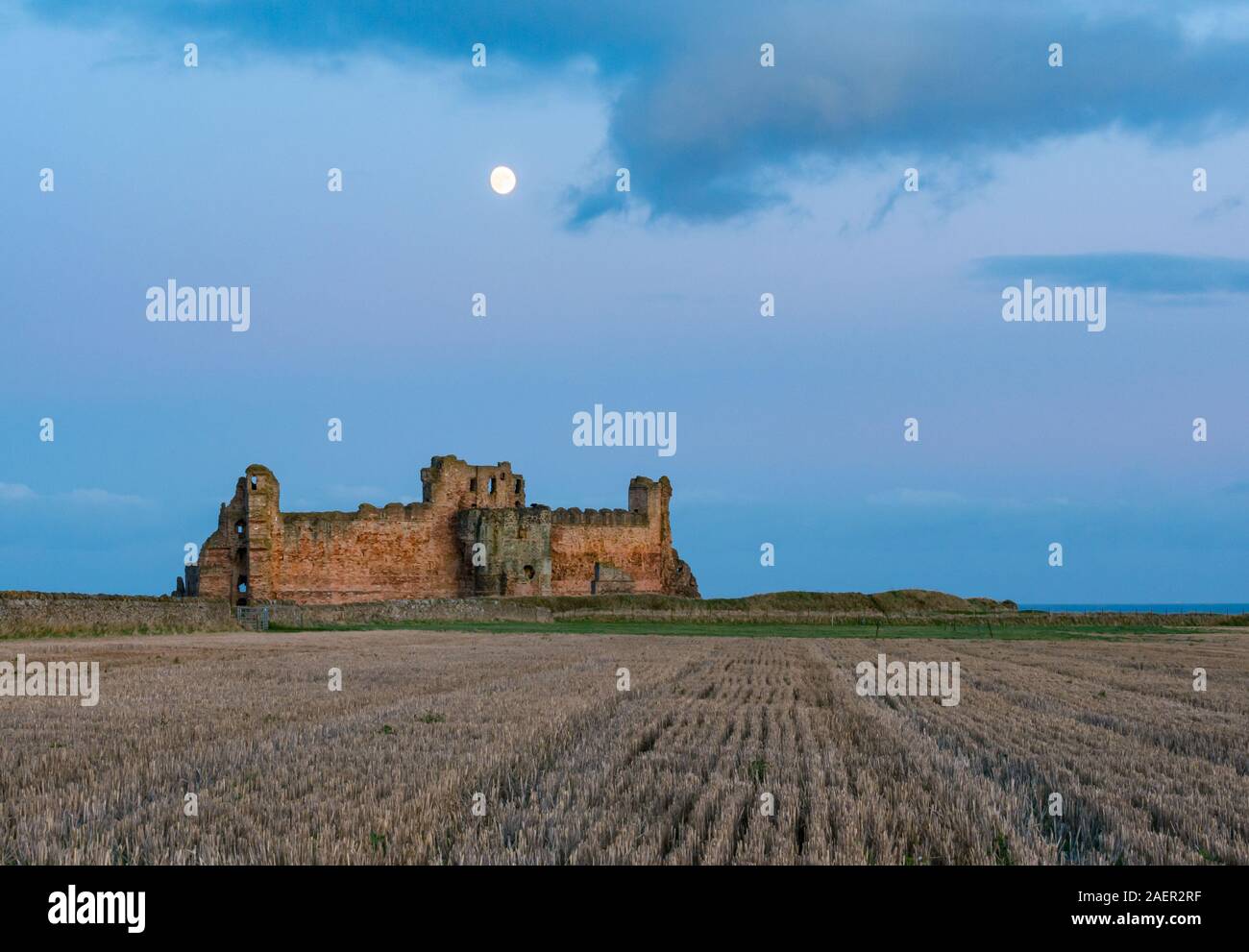 Un ciel clair avec Lune gibbeuse passant au-dessus du mur rideau en ruine de 14e siècle ruines du Château de Tantallon, East Lothian, Scotland, UK Banque D'Images