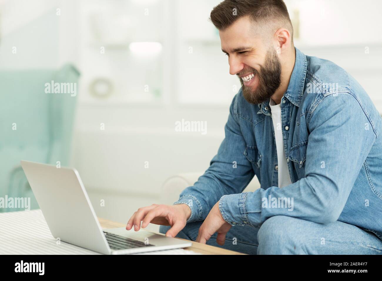Bureau à domicile. Happy Man working on laptop, taper au clavier Banque D'Images