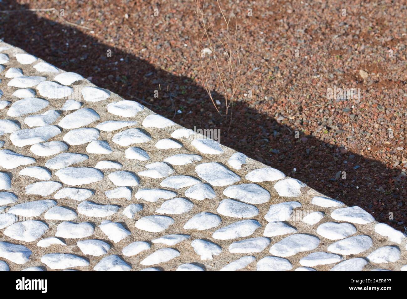 Construction d'une chaussée de galets en pierre avec un étage de galets de pierre arrondis blancs sur un sous-plancher de béton dans un chantier de construction Banque D'Images