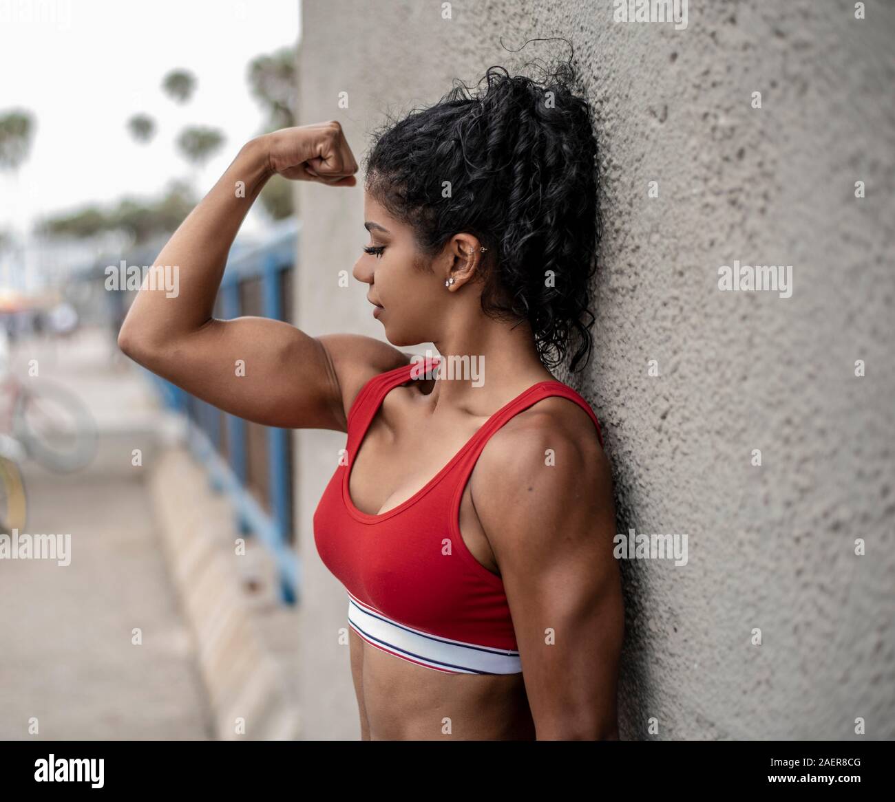 Forme physique woman wearing sports bra flexes muscles du bras. Banque D'Images