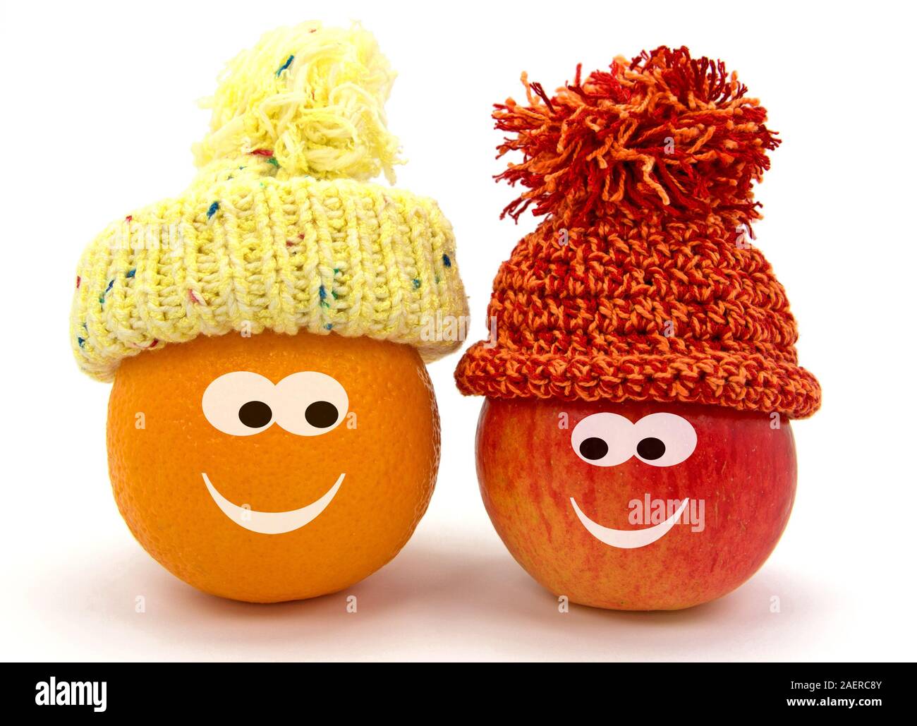 Les pommes avec drôle de visage et bobble hat Banque D'Images