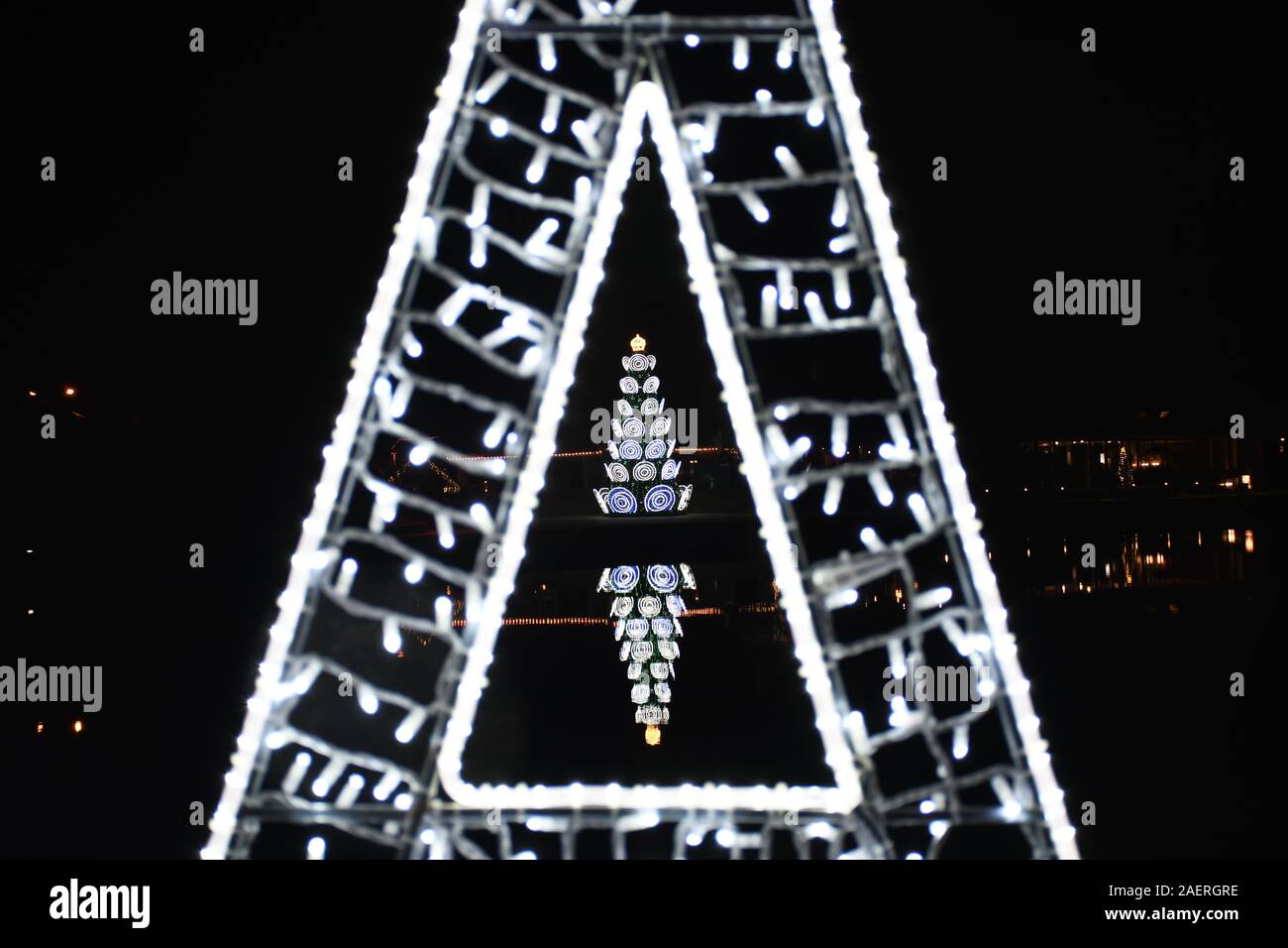 Arbre de Noël dans un triangle de lumières dans la nuit Banque D'Images