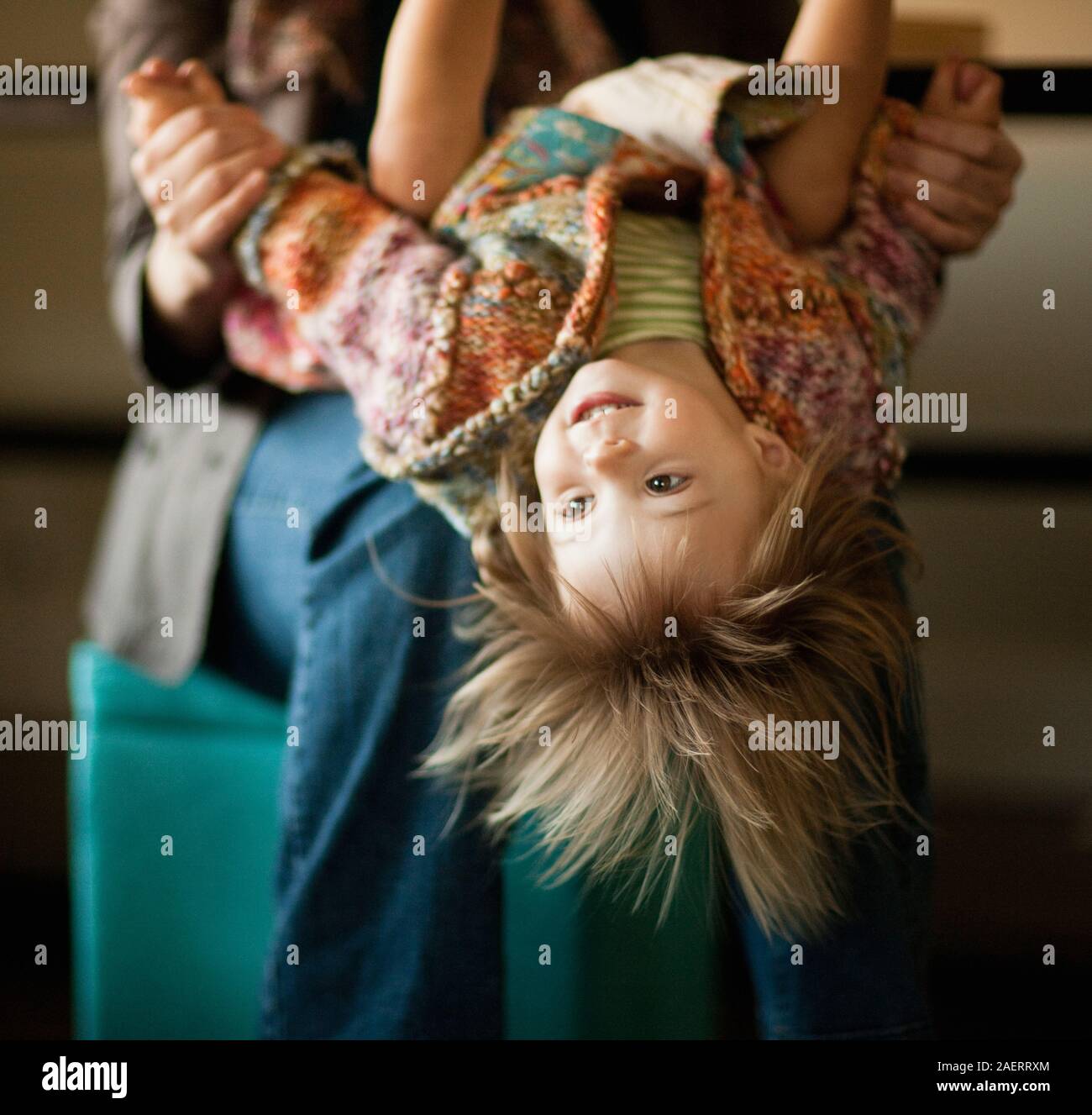 Toddler girl retour à l'envers sur les genoux de sa mère. Banque D'Images