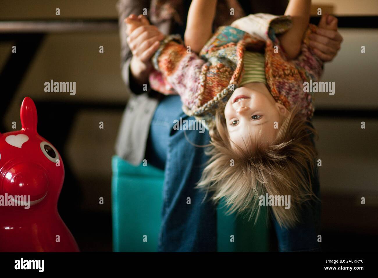Toddler girl retour à l'envers sur les genoux de sa mère. Banque D'Images