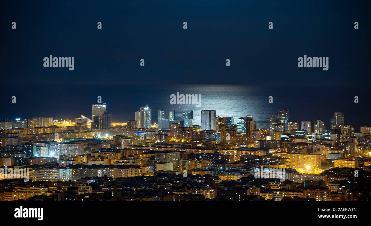 Barcelona skyline at night avec la lune sur la mer Banque D'Images