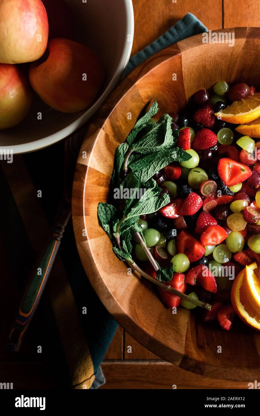 Mise à plat de fruits dans un bol en bois avec des pommes sur une table de cuisine Banque D'Images