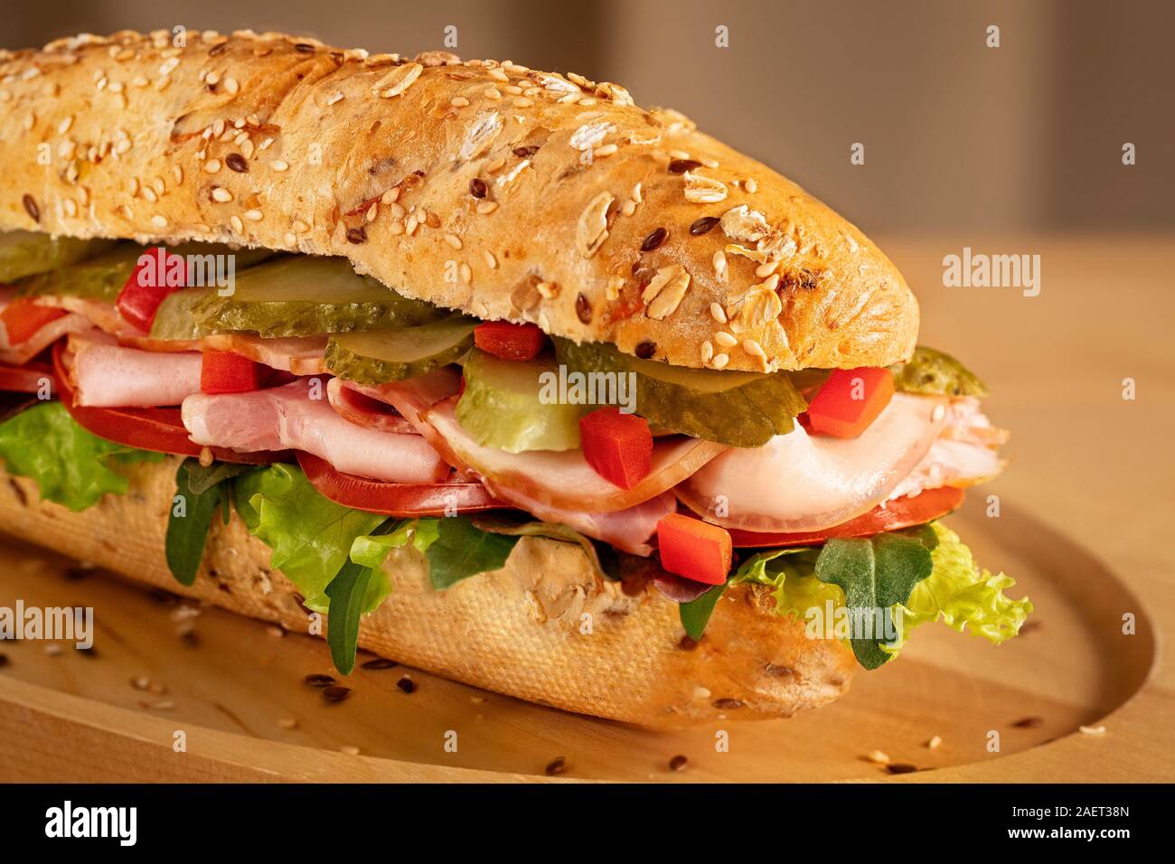 Sandwich avec jambon, cornichons, tomates fraîches et salade verte sur fond de bois Banque D'Images