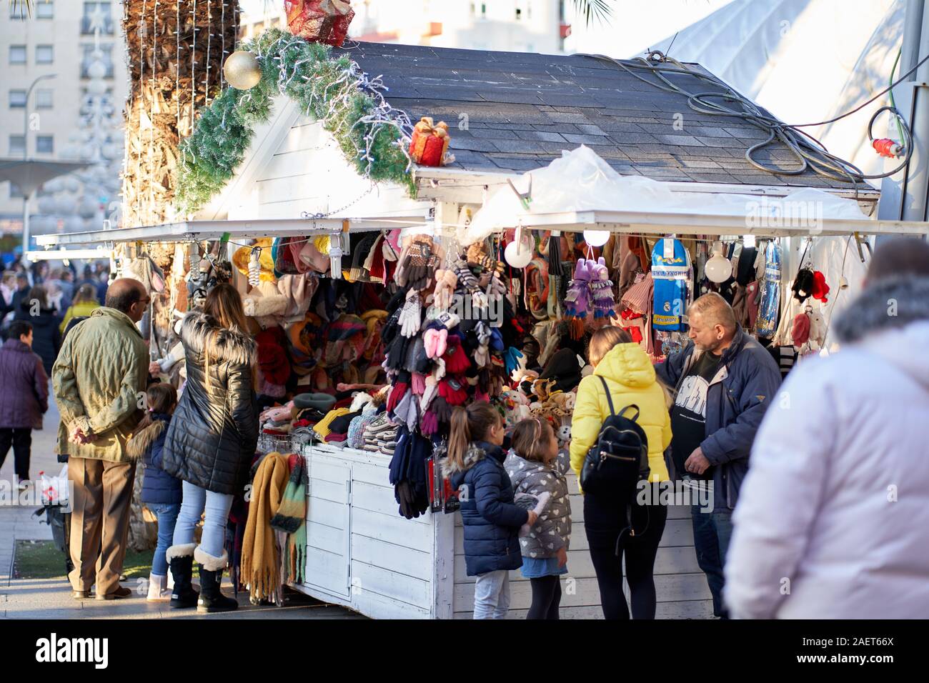 Des acheteurs parcourent des chapeaux en laine et des cadeaux dans une cabane de marché de Noël à Torrejón de Ardoz, Madrid, Espagne Banque D'Images