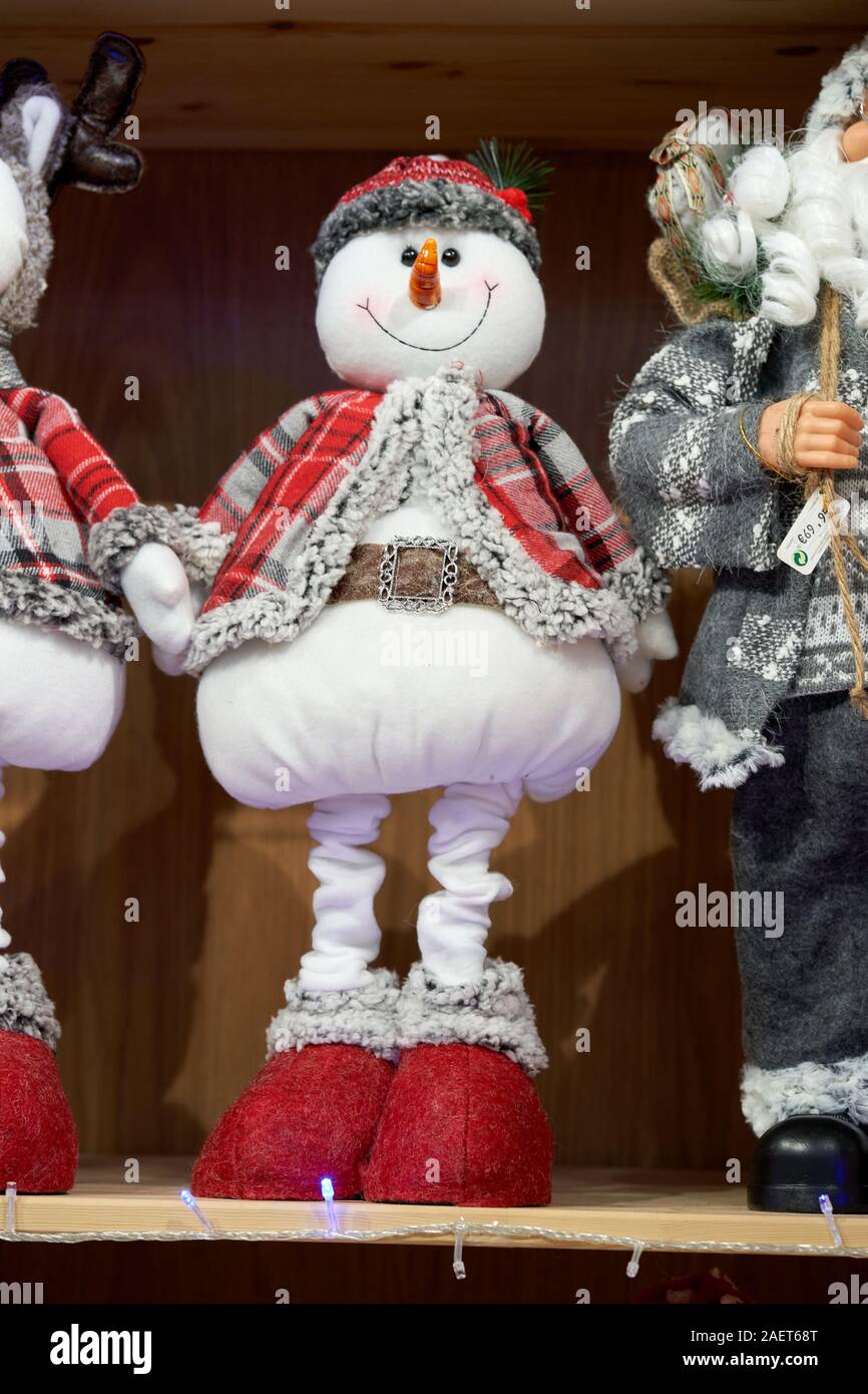 Peluche bonhomme de neige dans une veste à carreaux rouge et des pantoufles rouges sur une étagère de magasin à la foire de Noël, Torrejon de Ardoz, Madrid, Espagne Banque D'Images