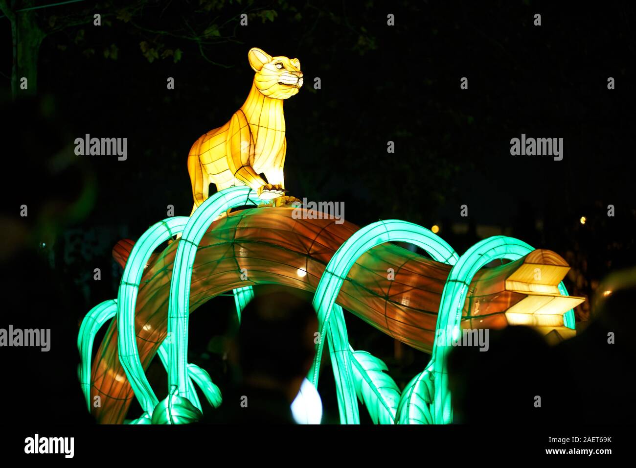 Un grand chat éclairé sur une branche couverte de vignes à la foire de Noël Torrejon de Ardoz Banque D'Images Un grand chat éclairé sur une branche couverte de vignes à la foire de Noël Torrejon de Ardoz Banque D'Images