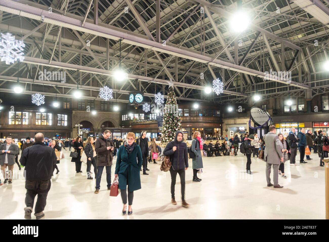 Les passagers debout, assise et la marche autour de l'arbre de Noël entièrement décorée dans le centre de le grand hall de la gare centrale de Glasgow, à Glasgow, Ecosse Banque D'Images