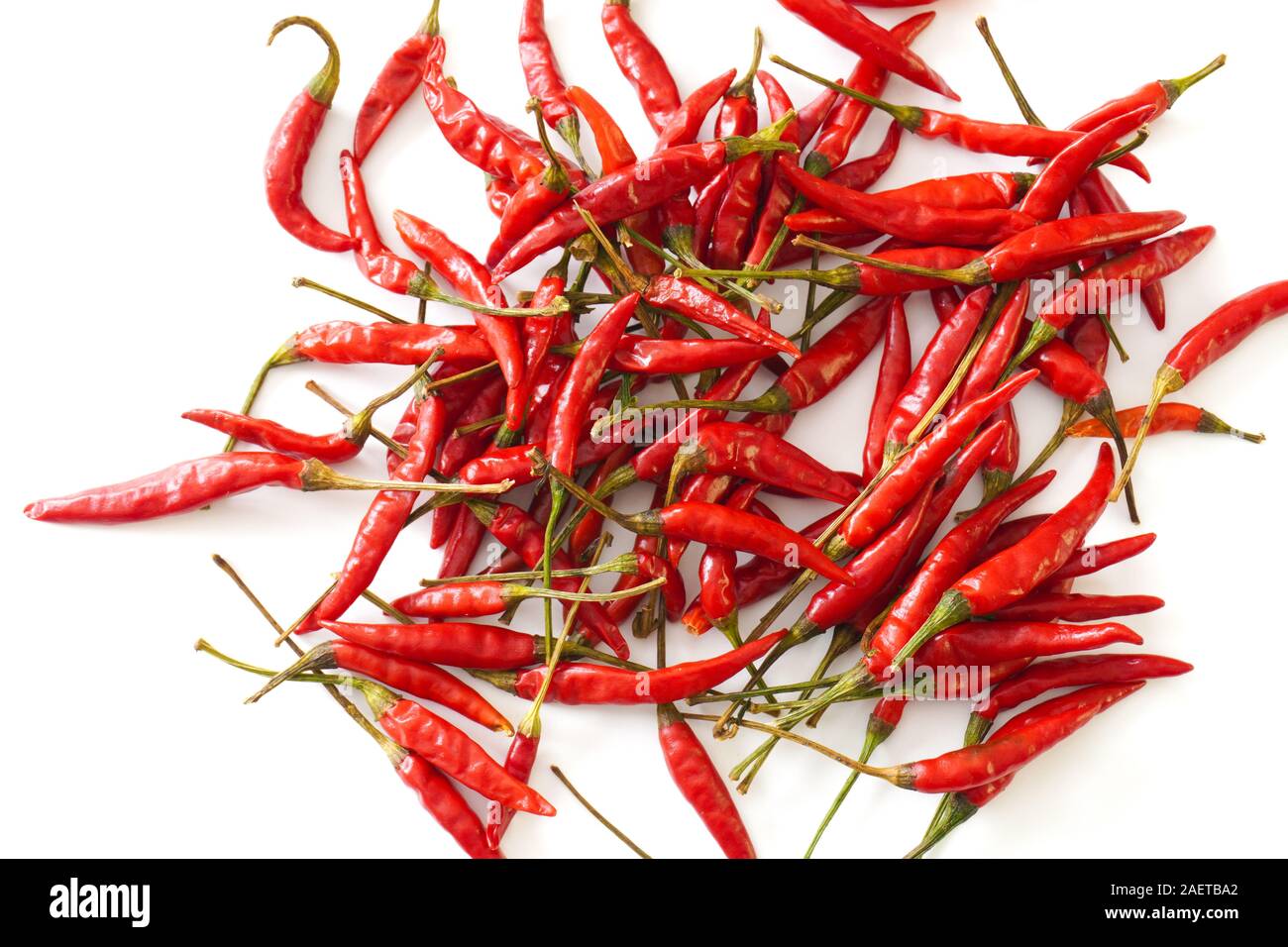 Close-up d'un rouge vif oiseaux Thai chiles isolé sur un fond blanc ; la préparation des aliments Banque D'Images