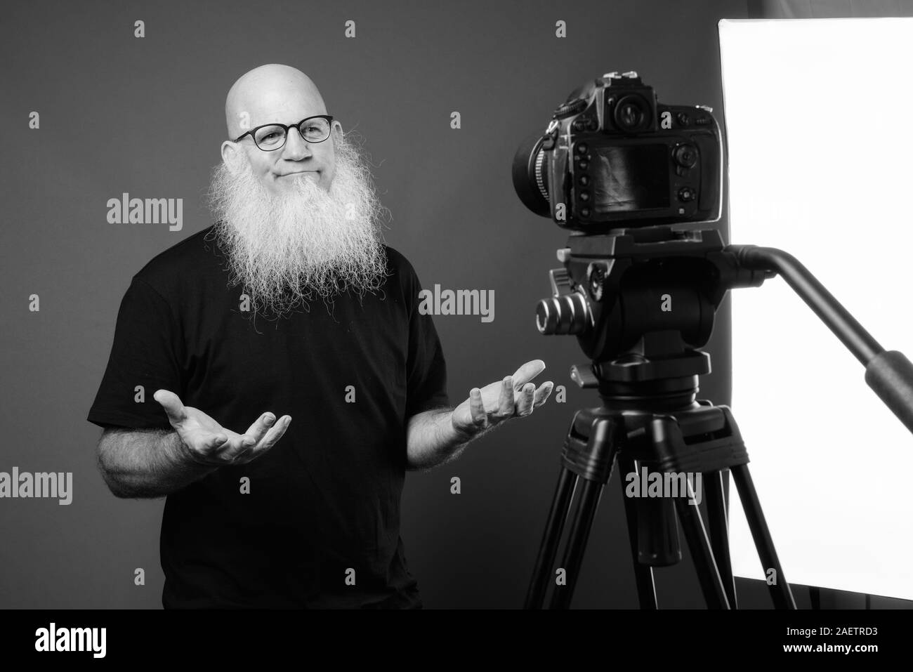 Homme chauve avec maturité longue barbe vlogging en noir et blanc Banque D'Images