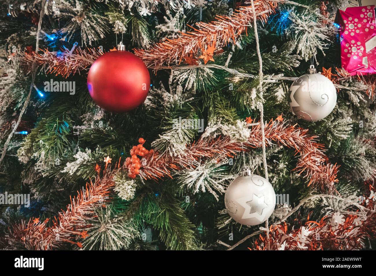 Arbre de Noël décoré libre. Boules rouge et argent et allumé garland avec lampes de poche. Nouvelle Année baubles macro photo avec effet bokeh. Hiver holid Banque D'Images