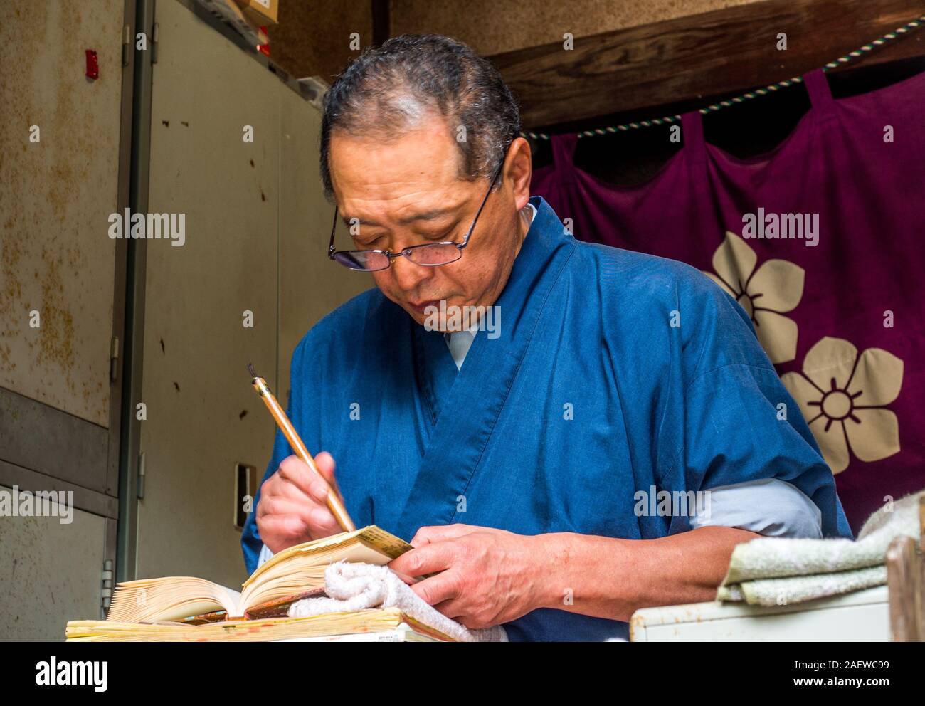 Prêtre du Temple dans nokyocho écrit nom pèlerinage livre, Meisekiji, temple 43 Temple 88 de pèlerinage, Ehime, Shikoku, Japon Banque D'Images