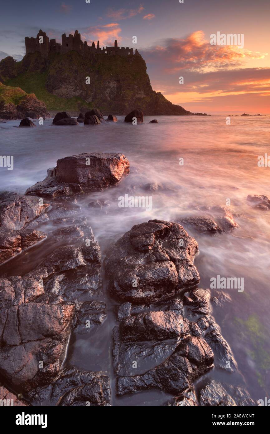 Les ruines de la château de Dunluce sur la côte de Causeway d'Irlande du Nord. Photographié au coucher du soleil. Banque D'Images