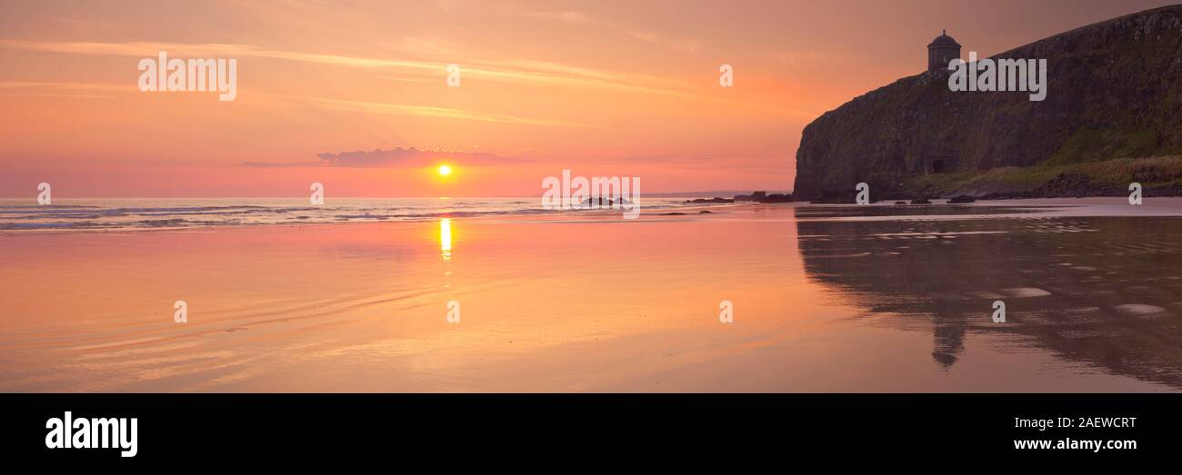 Lever de Soleil sur le plage et falaises de la côte de Causeway en Irlande du Nord. Banque D'Images