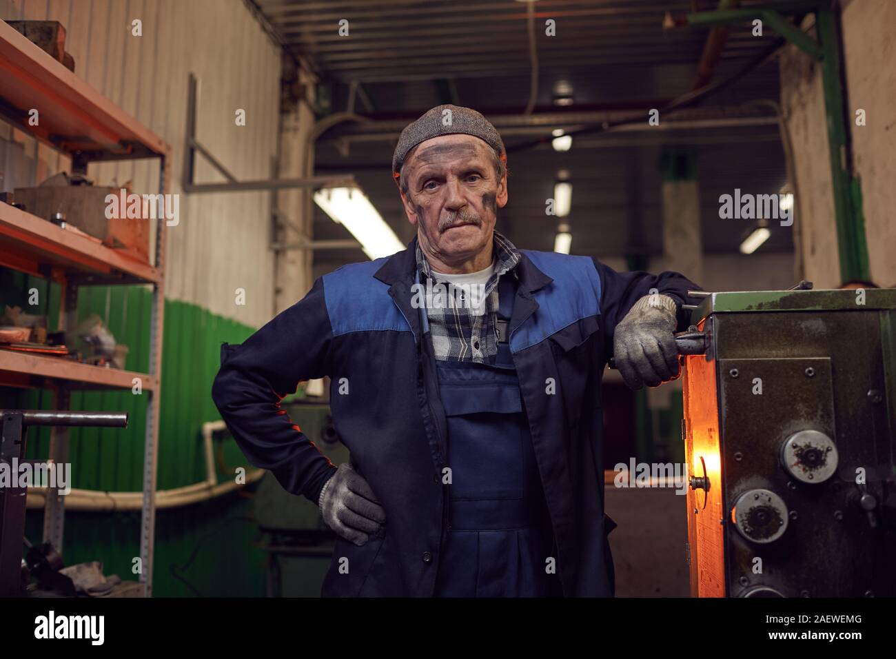 Portrait of mature travailleur dans le cadre de son travail à l'usure à la caméra alors que l'article dans l'usine Banque D'Images